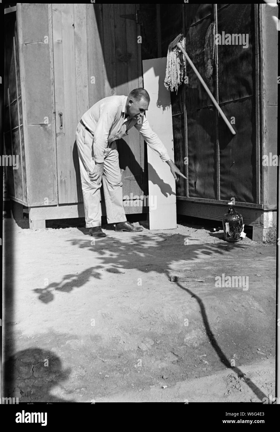 Il fiume Colorado Relocation Center, Poston, Arizona. William Hoffman, il capo della protezione antincendio Se . . .; Portata e contenuto: tutta la didascalia per questa fotografia si legge: Fiume Colorado Relocation Center, Poston, Arizona. William Hoffman, il capo della protezione antincendio Sezione di War Relocation Authority a bruciato impeci carta sul lato di caserme G, blocco 34, dove un incendio creduto di origine incendiari aveva scoperto. Questo è stato uno dei tre di tali incendi scoperto in meno di un ora nei quartieri occupati da personale nominato a questo War Relocation Authority center. Foto Stock