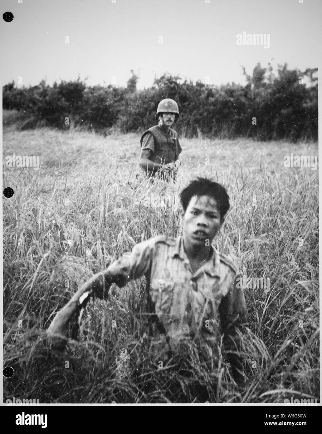 Caporale Atchley (Long Beach, CA), un leader di squadra della società B, 1° Battaglione, 9 Marines, protezioni un Viet Cong come egli si sposta verso il punto di raccolta. Azione ha avuto luogo durante il funzionamento Vello d'oro. Foto Stock