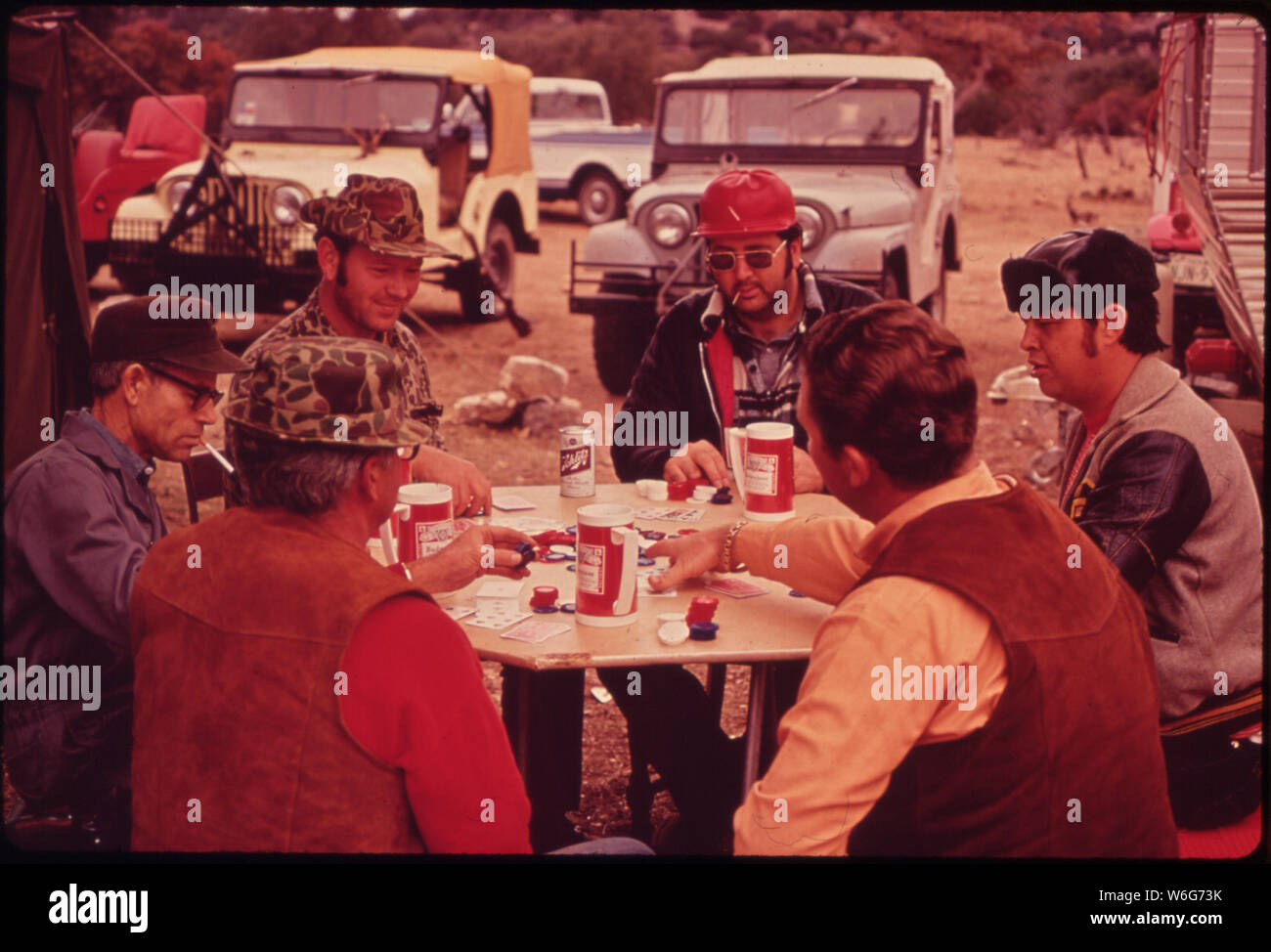 I cacciatori di cervi rilassarsi tra uccide la loro permanente CAMP IN UNA quasi inaccessibile parte della foresta. Essi IMPOSTARE IL CAMP attraverso l uso di jeep e AIRLIFTS. Essi sono (in senso orario) DR Harold Wood (giubbotto in pelle e CAMOUFLAGE HAT), JACK HILLIARD, Ken Davenport, FRANK STUMBAUGH, Larry ROMING E MALCOLM THORNTON Foto Stock