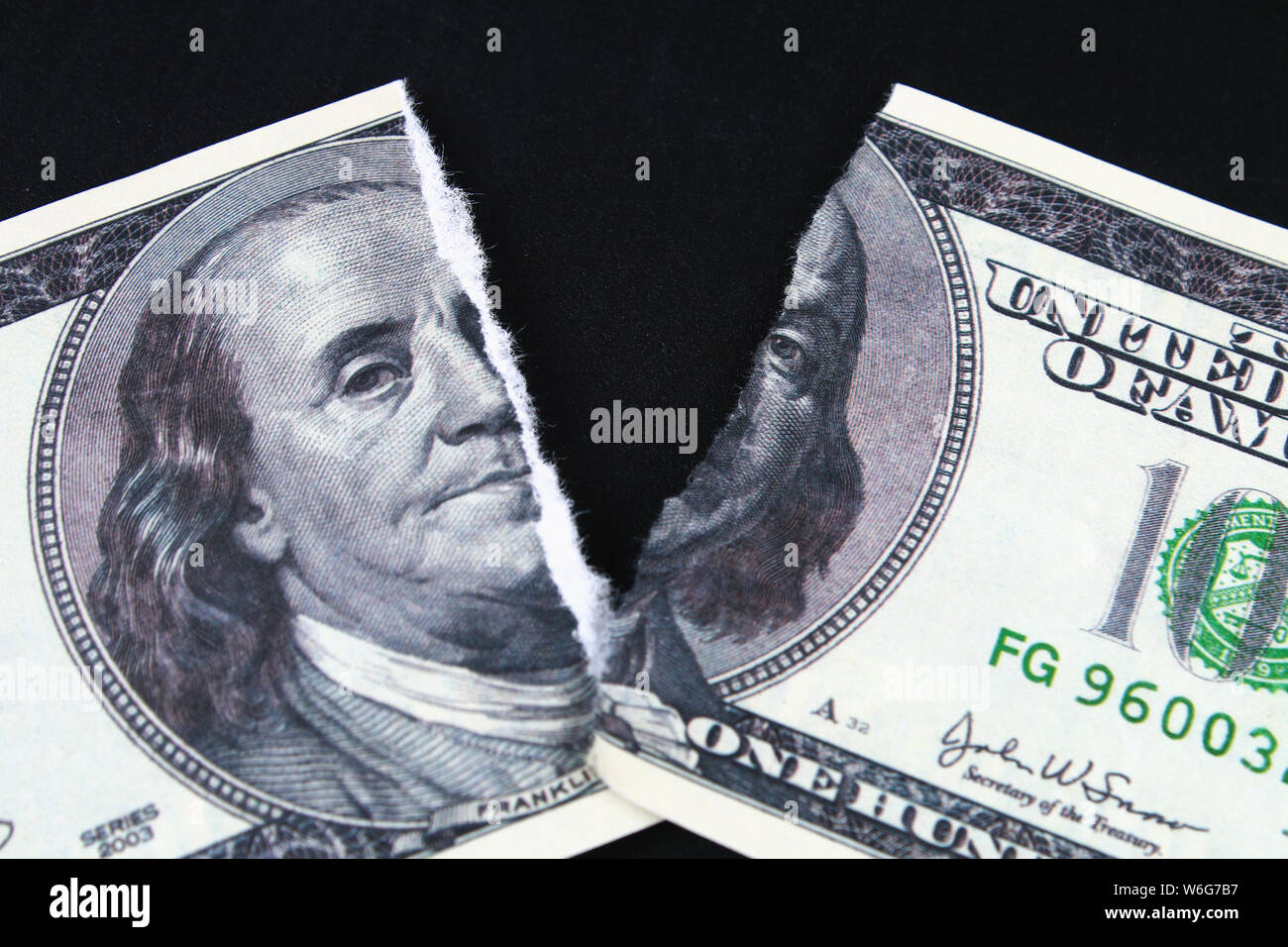Strappato strappato svalutato di un centinaio di dollari nota banca su uno sfondo nero. close-up di bad denaro. Il crollo del dollaro. Svalutazione. Curre caduta Foto Stock