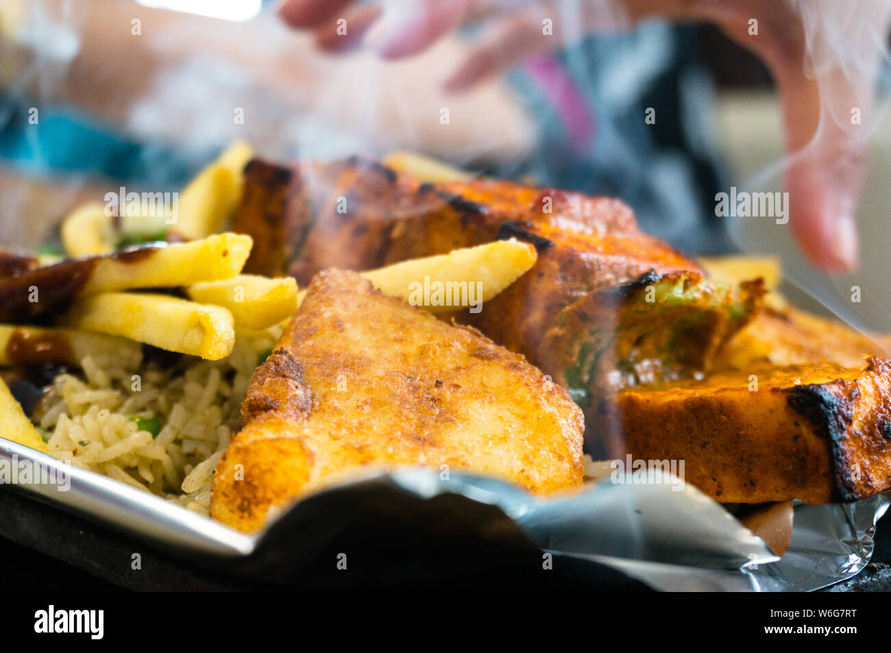 Delizioso il paneer, patatine fritte e vegetble sizzler dando fuori il fumo e vapore Foto Stock