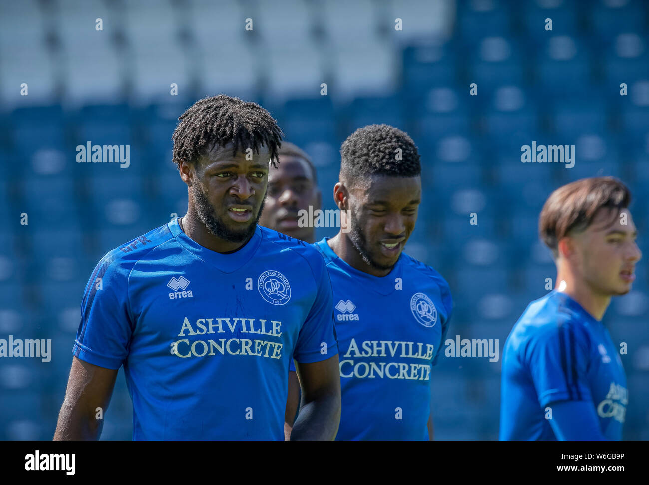 Diversi QPR ai giocatori di prendere un periodo di riposo durante una sessione di formazione a Loftus Road London W12 incluso il calciatore Oteh Aramide Foto Stock