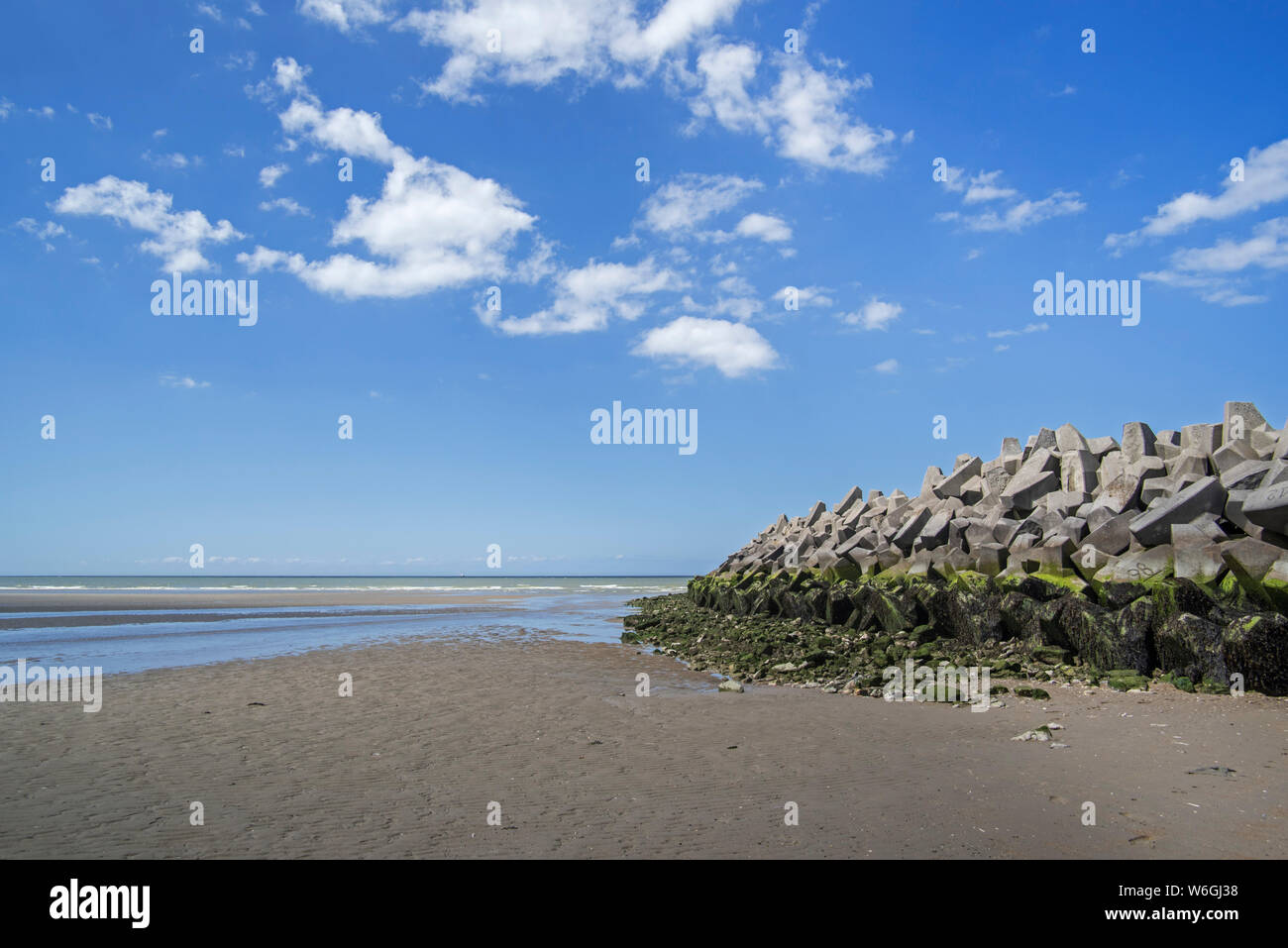 Mound tipo parete del mare / seawall / dam fatti di blocchi di cemento, la difesa costiera a Grand-Fort-Philippe, Pas-de-Calais, Hauts-de-France, Francia Foto Stock