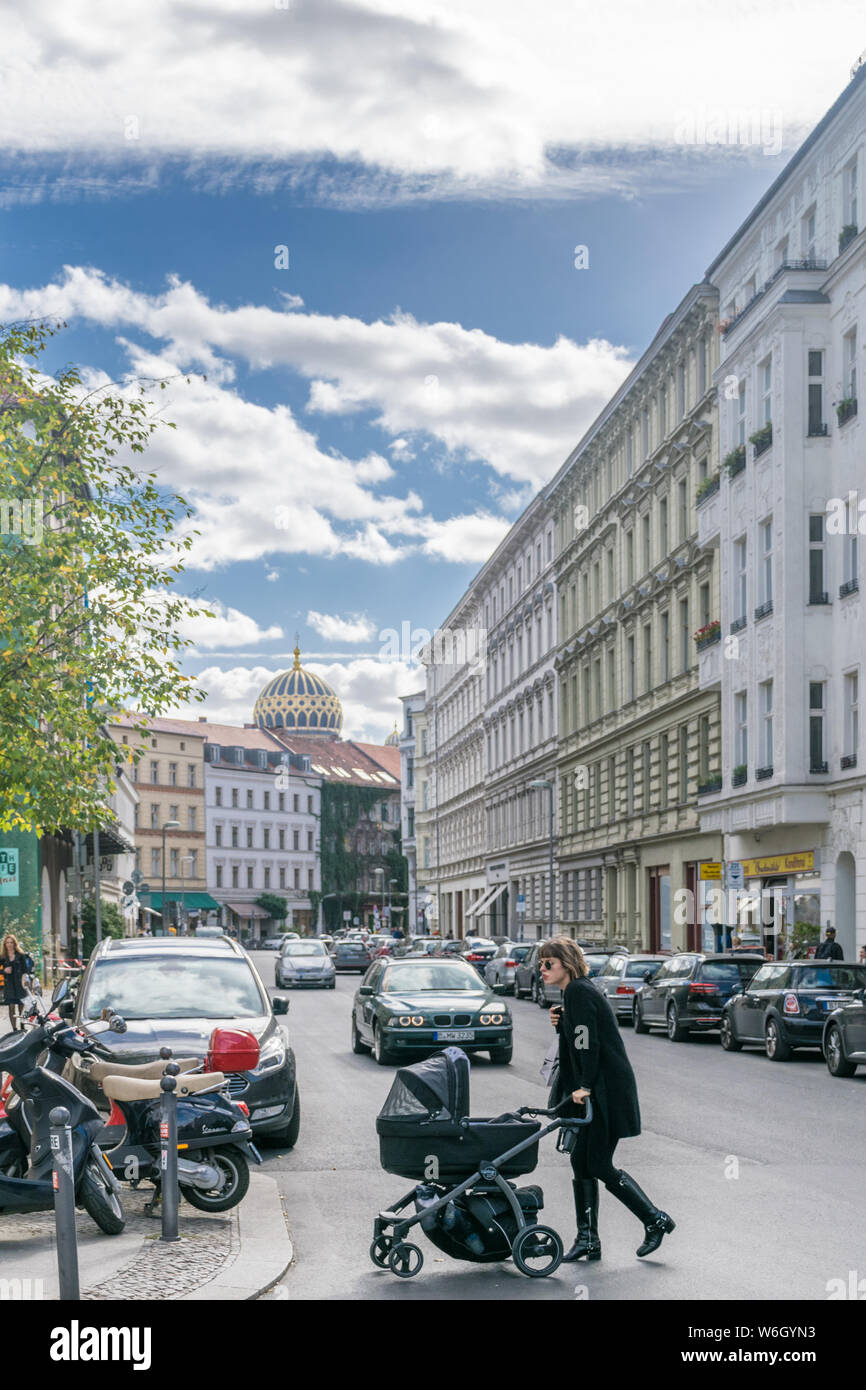 Berlino, Germania - 26 settembre 2018: vista verticale di una madre che attraversa la strada con un passeggino vicino al Neue Synagogue, un punto di riferimento degli ebrei Foto Stock