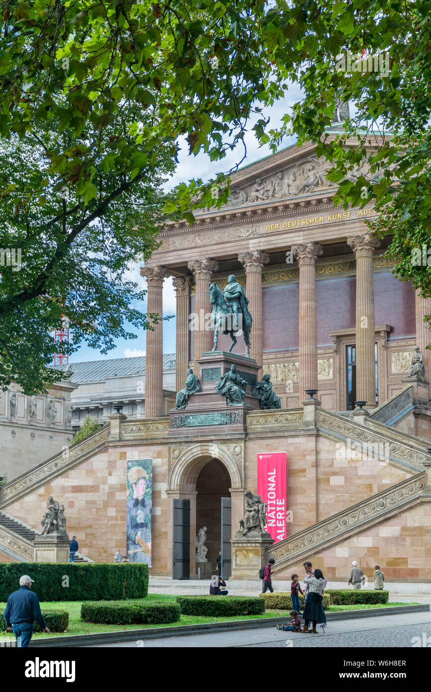 Berlino, Germania - 26 Settembre 2018: vista incorniciata dagli alberi del giardino anteriore, ingresso scale e la facciata della Alte Nationalgalerie, a 158 anni Foto Stock