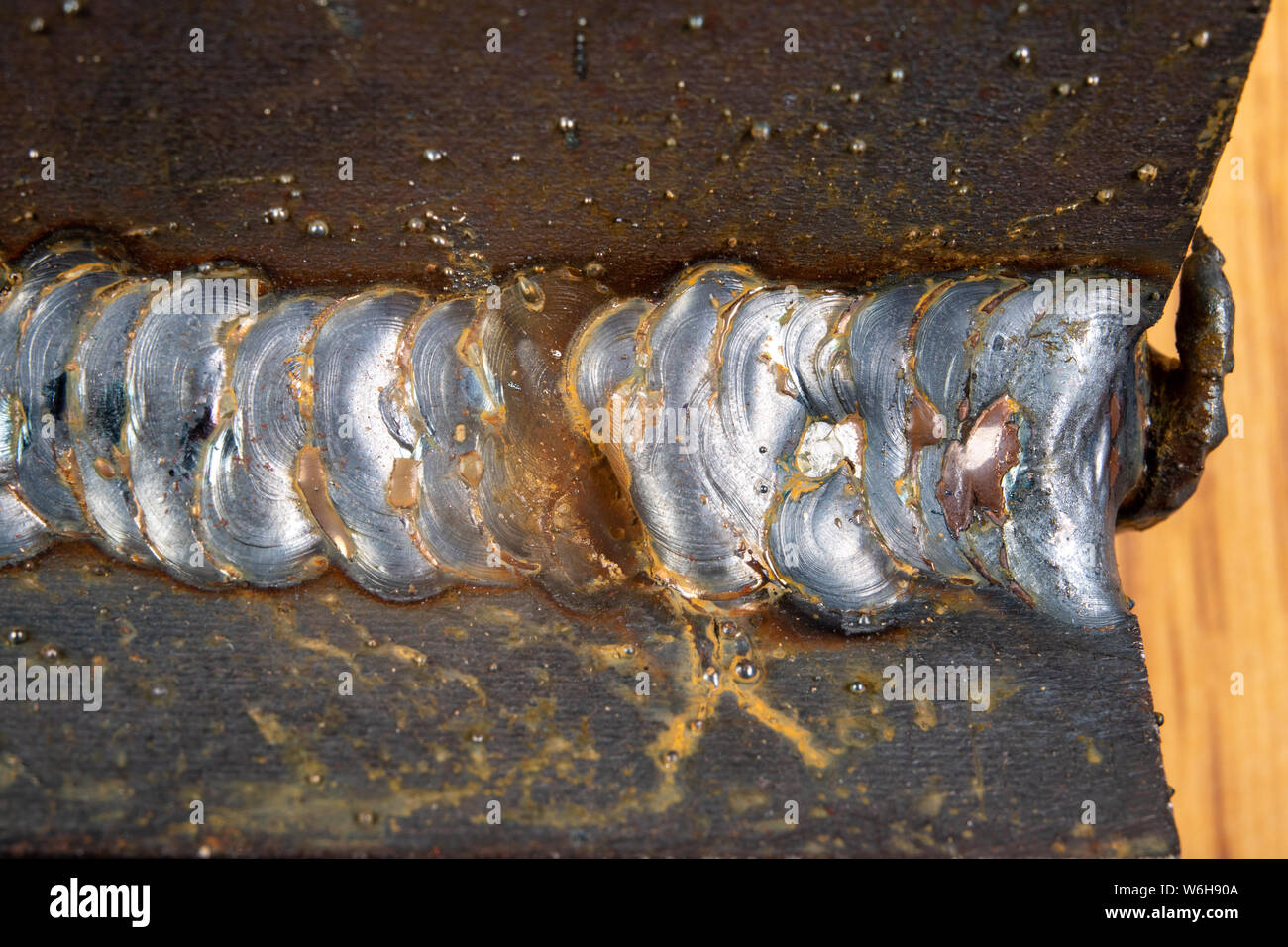 Il filetto saldatura viene effettuata utilizzando il metodo MAG. Errori nelle connessioni di acciaio mediante saldatura ad arco. Sfondo scuro. Foto Stock