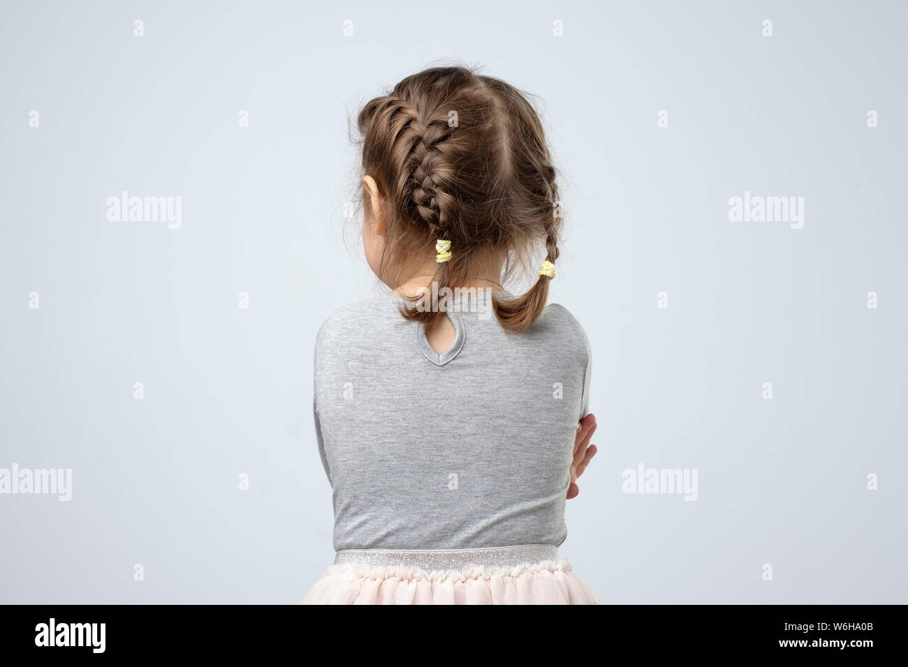 Vista posteriore della piccola ragazza caucasica. Kid è perso o essere offeso sui genitori. Foto Stock