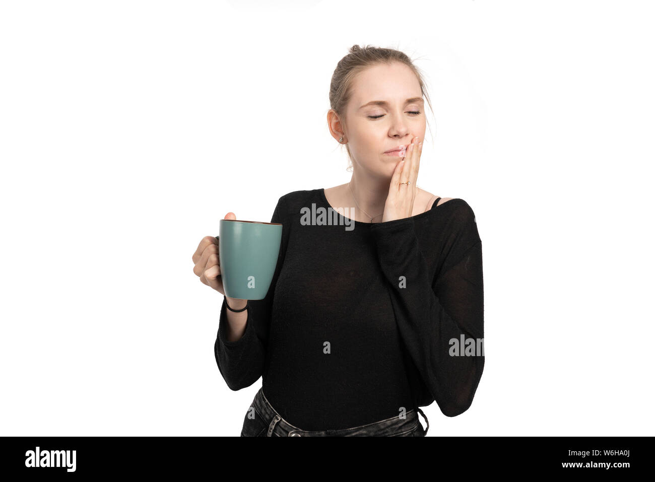 Una giovane donna è sensibile quando bere bevande calde e ottenere il mal di denti Foto Stock