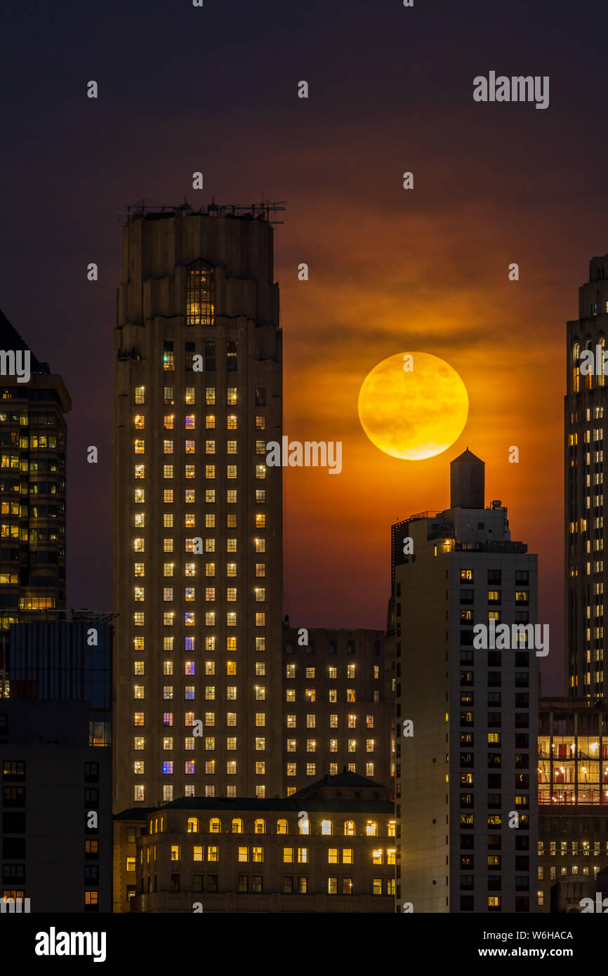 Luna piena al di sopra dello Skyline di Manhattan di notte Foto Stock