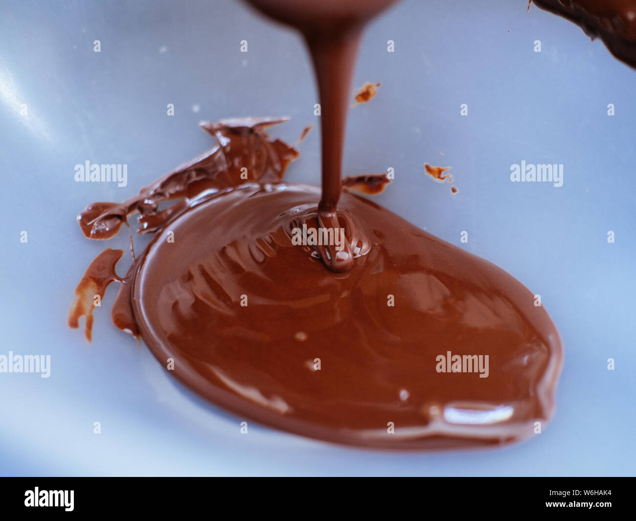 Liquido di cioccolato fuso essendo sceso su di uno stampo per vegan uova di pasqua Foto Stock