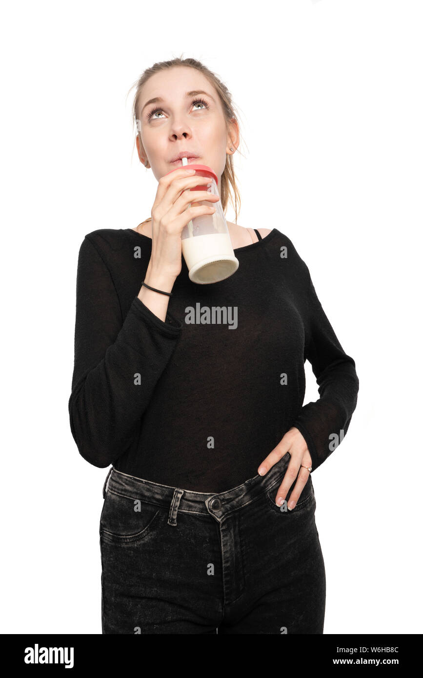Una giovane donna in possesso di un bicchiere di latte e bevande Foto Stock