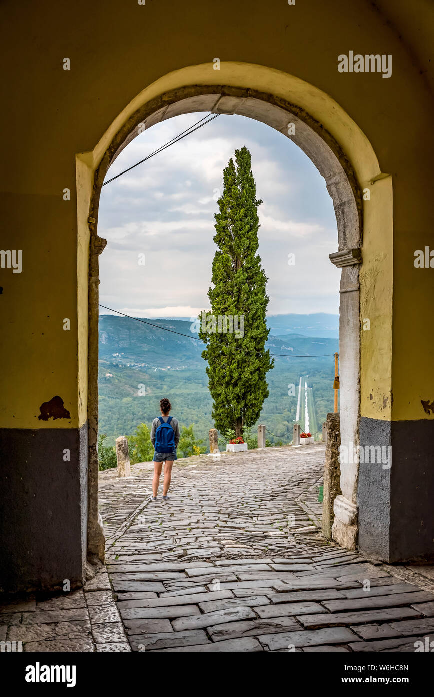 Turista femminile guardando fuori dalla collina del borgo medievale di Montona; Montona, Istria, Croazia Foto Stock