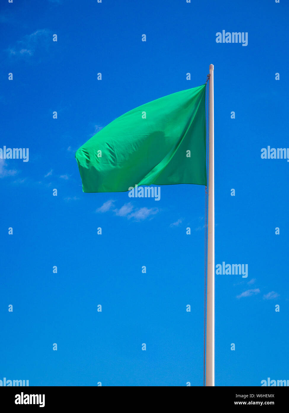 Bandiera verde isolato sventola sul cielo Foto Stock