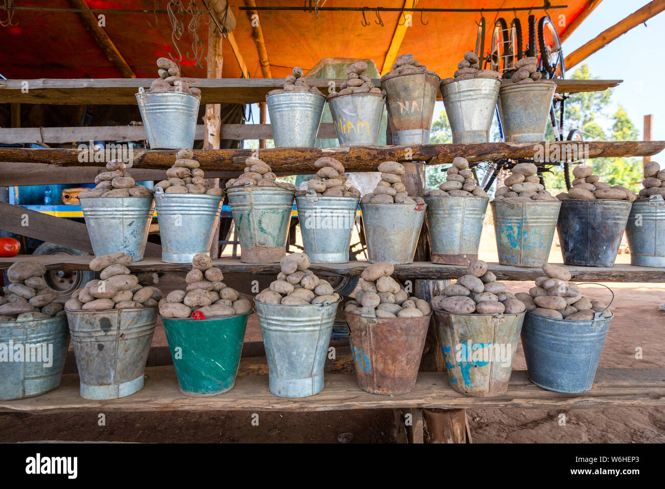 Un africano del Malawi stallo alimentari vendita di patate fresche in ferro bucket in una strada locale mercato alimentare. Lilongwe, Malawi Foto Stock