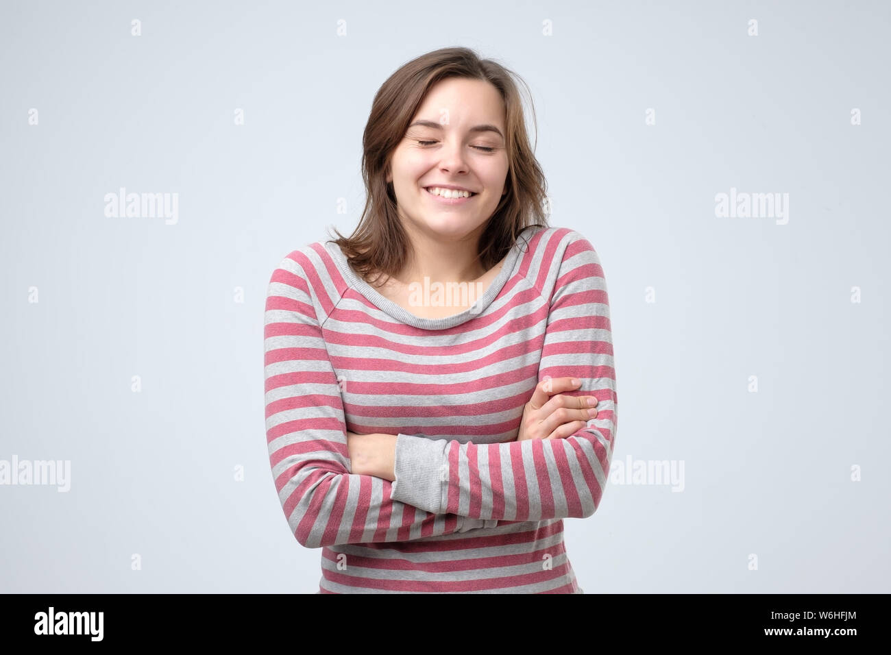 Giovane donna che guarda la fotocamera con gioiosa e affascinante sorriso Foto Stock