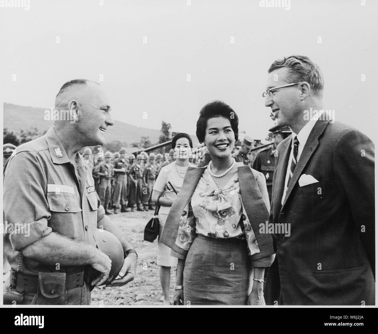 Re Bhumibol e Queen Sirikit di Thailandia visita negli Stati Uniti Dell'esercito fanteria 27 Wolfhound vicino a Korat, Thailandia. Qui, il Queen Sirikit visite con il Colonnello William McKean, comandante della 27th, E DEGLI STATI UNITI Ambasciatore di Thailandia, Kenneth T. Giovani, Jr. Le forze statunitensi in Thailandia sono usati per assistere come istruttori e consulenti. Foto Stock