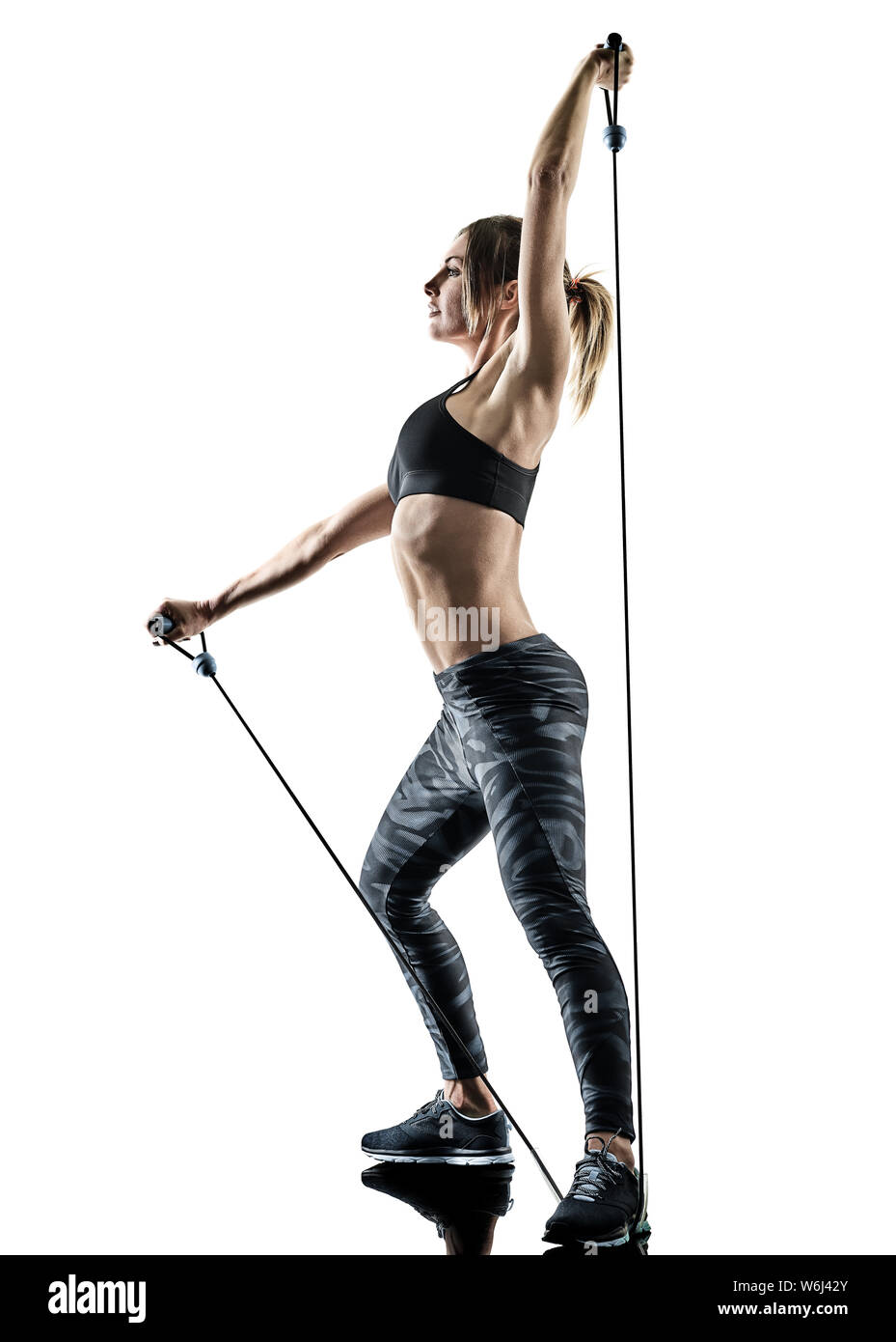 Una donna caucasica esercizio fitness pilates elastico fascia resistente agli esercizi di silhouette isolato su sfondo bianco Foto Stock
