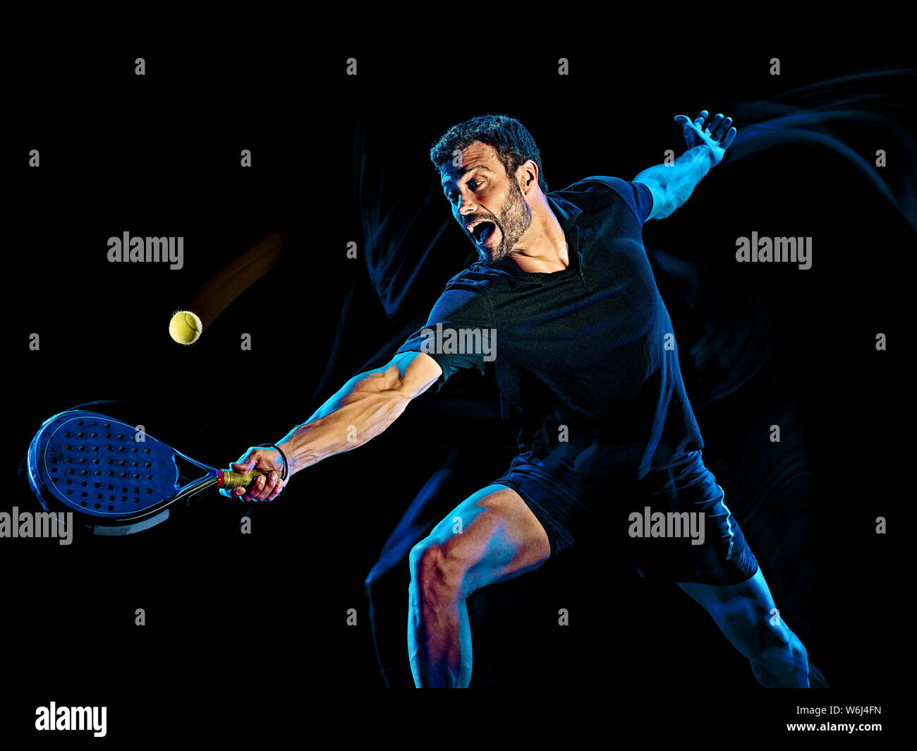 Una paletta caucasica giocatore di tennis uomo studio shot isolato su sfondo nero con luce di verniciatura effetto di sfocatura Foto Stock