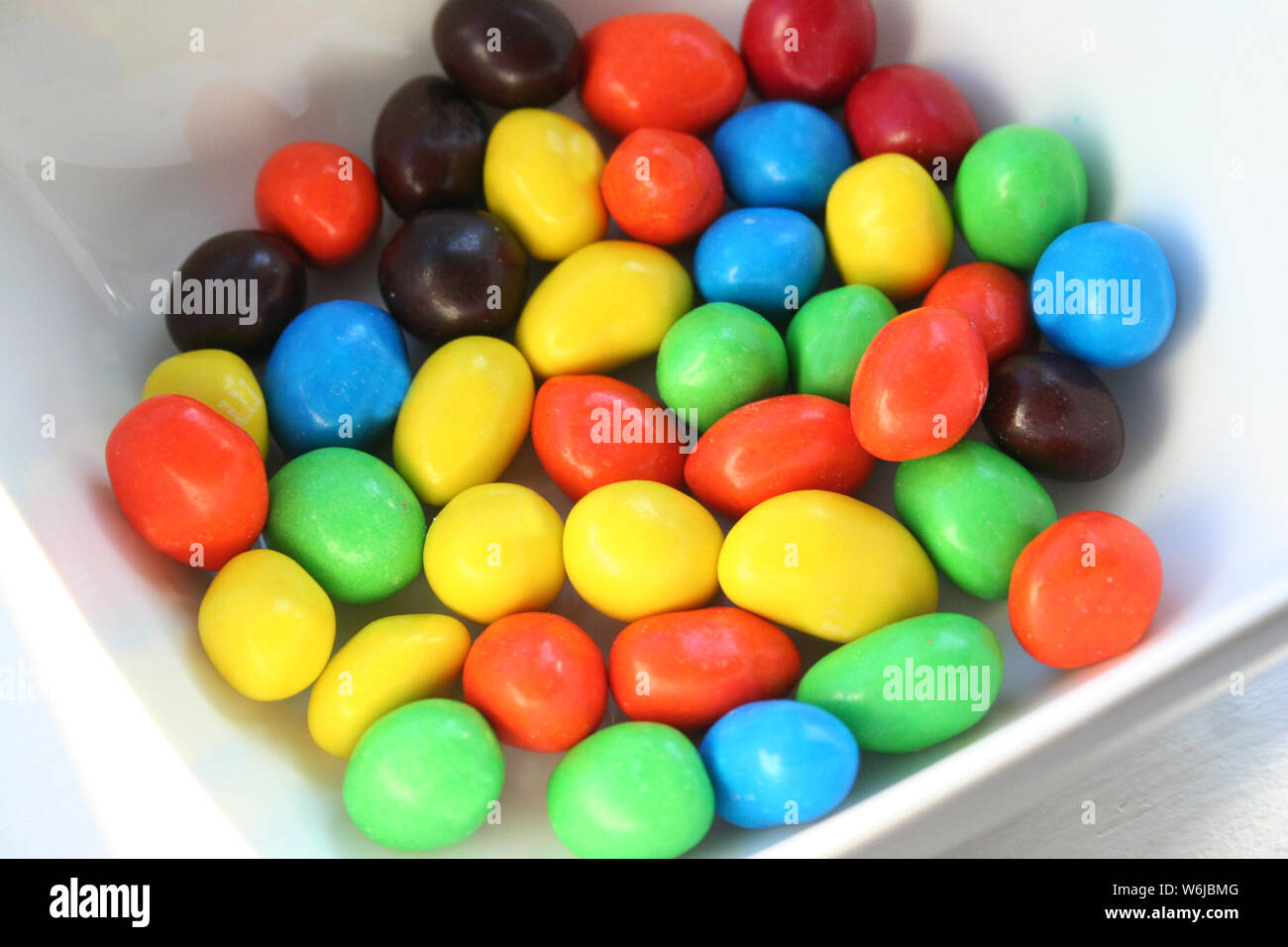 Disco colorato di arachidi caramella di cioccolato in un piatto bianco, nei colori del rosso verde blu e marrone Foto Stock