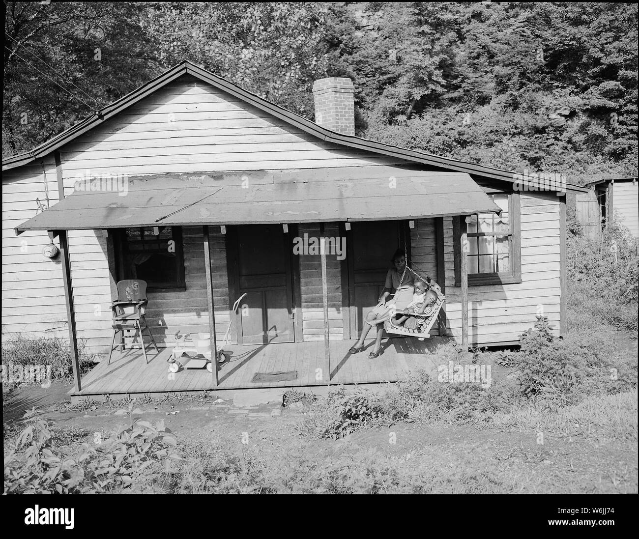 La sig.ra Beulah Wady, moglie di minatore e i bambini sulla parte anteriore portico dei loro cinque camera Casa per cui essi pagare $9 mensilmente; tar carta perdite del tetto. Kingston Pocahontas Coal Company, Exeter miniera, Welch, McDowell County, West Virginia. Foto Stock