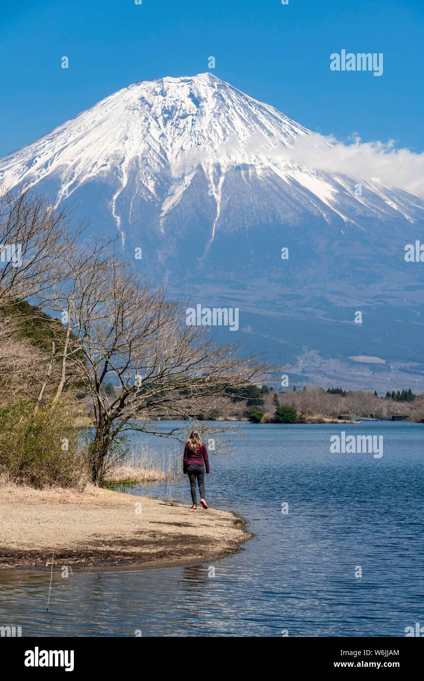 Giovane donna sulla riva, vista su un lago al vulcano Monte Fuji, Tanuki Lago, Prefettura di Yamanashi, Giappone Foto Stock