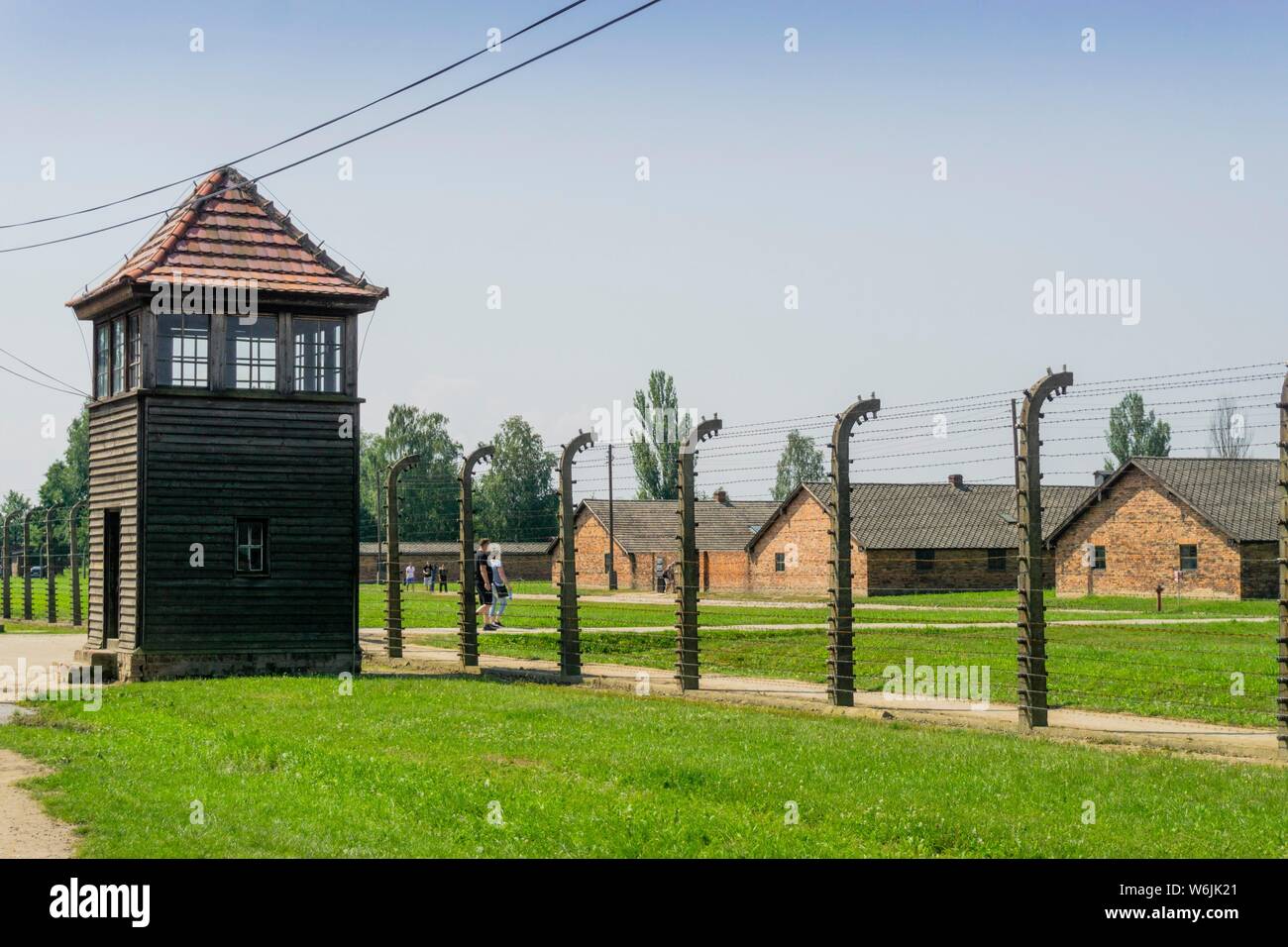 Recinzione e torre di avvistamento che circonda gli edifici residenziali nel campo di concentramento di Auschwitz-Birkenau utilizzato dai Nazisti durante la Seconda Guerra Mondiale, Polonia Foto Stock