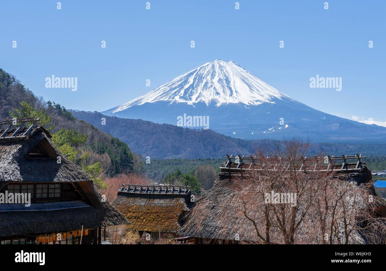 Vista sul vulcano Mt. Fuji, open air museum Iyashinosato, vecchio villaggio Giapponese con le tradizionali case in paglia, Fujikawaguchiko, Giappone Foto Stock