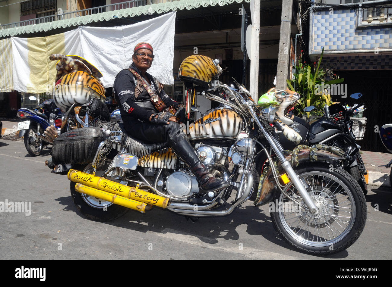 Malaysian biker pone con orgoglio sulla sua moto durante una riunione di motociclisti in Sadao, Thailandia. Foto Stock