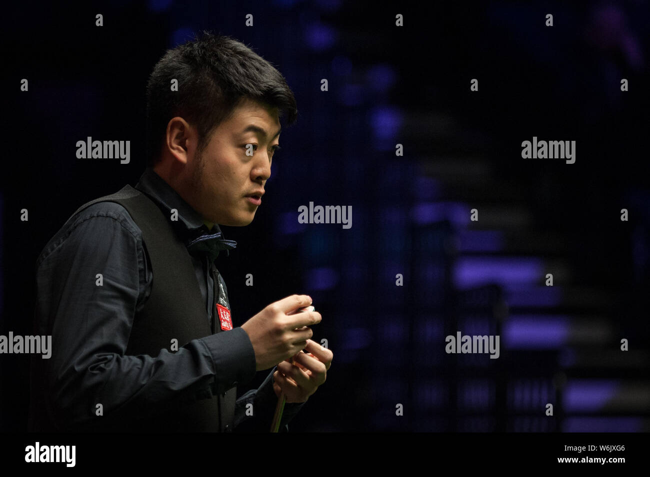 Liang Wenbo della Cina ritiene che un colpo di Alfie onere di Inghilterra nel loro primo incontro durante il 2018 ManBetX Welsh Open snooker nel torneo di Cardiff Foto Stock