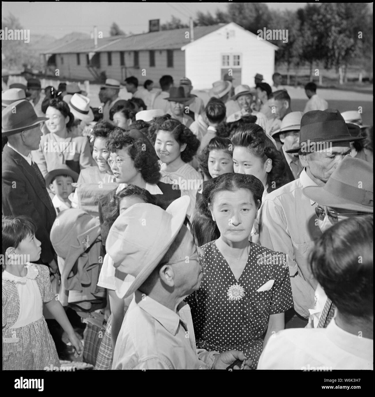 Poston, Arizona. Sfollati stand in linea prima della stazione di partenza in cui essi vengono a ricevere thei . . .; Portata e contenuto: tutta la didascalia per questa fotografia si legge: Poston, Arizona. Sfollati stand in linea prima della stazione di partenza in cui essi ricevono la loro razione di libri e biglietti del bus. Dopo la finale i piani sono stati realizzati, scatole confezionate e sovvenzioni prelevate, i residenti di Poston sono finalmente pronto a lasciare il centro. Ora che così tanti di loro amici sono andati fuori prima di loro, è con un sentimento di anticipazione piuttosto che uno di dolore che gli sfollati prepararsi a lasciare il pla Foto Stock