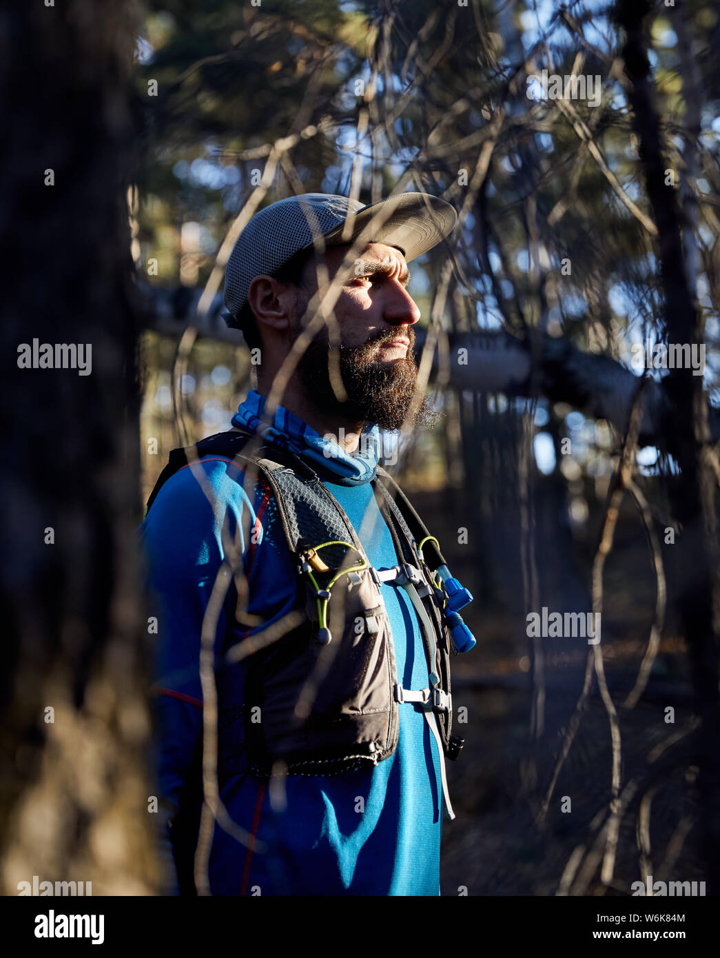 Ritratto di runner atleta con la barba in maglietta blu nella foresta Foto Stock