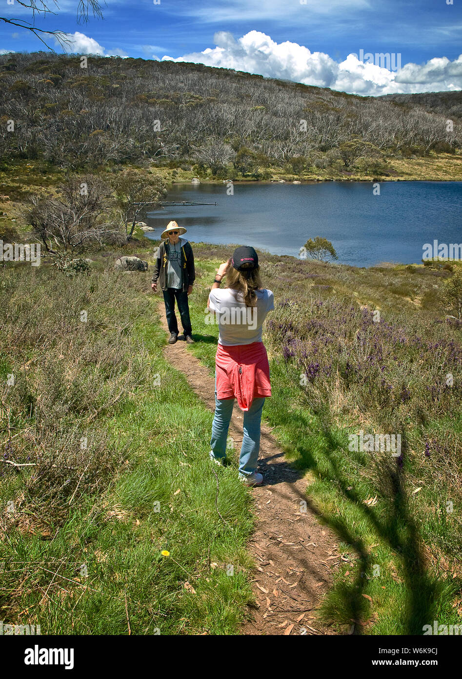 I turisti rendendo fotografia sopra il lago di Rainbow in Australia la montagne innevate Foto Stock