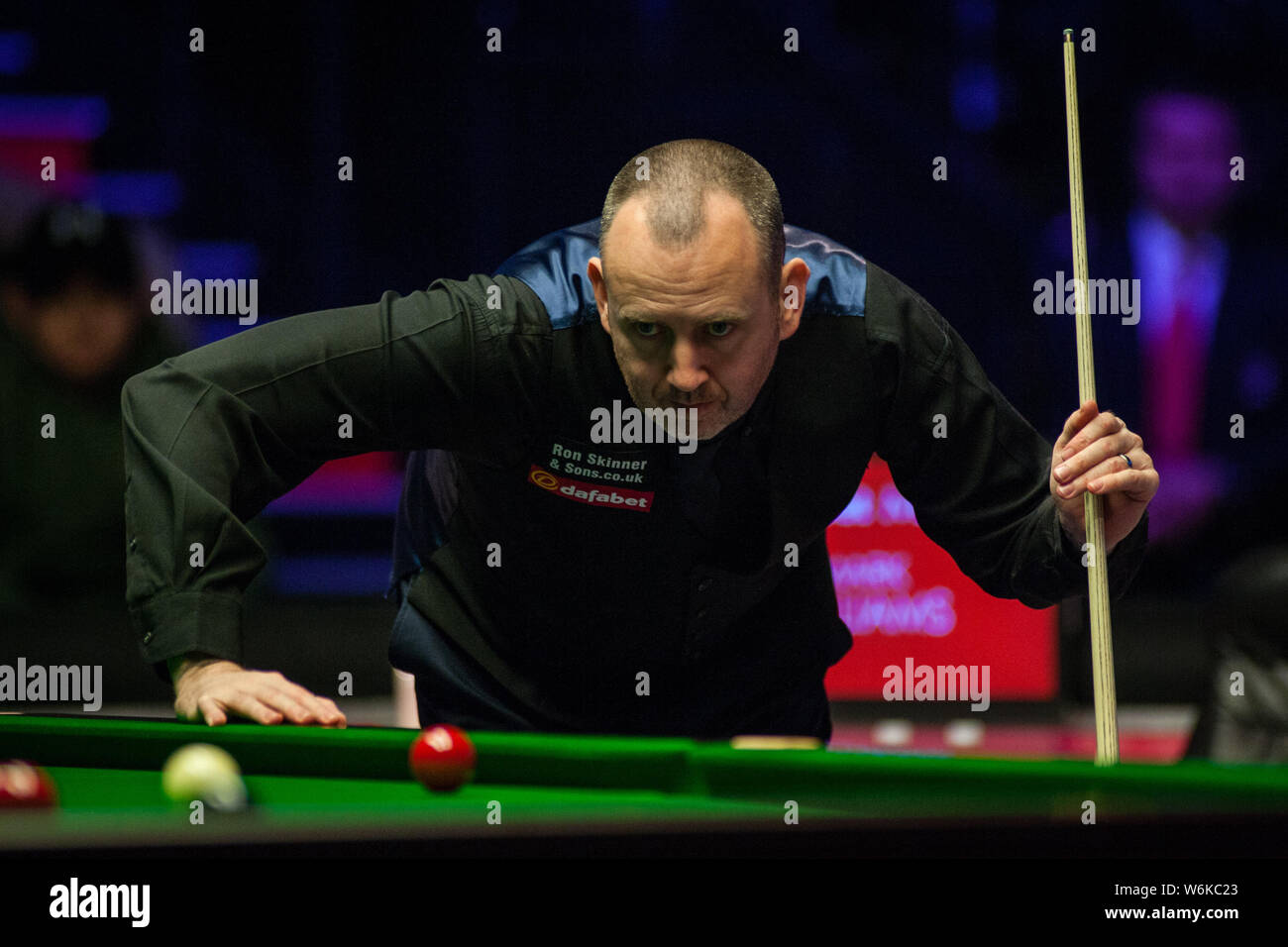 Mark Williams del Galles ritiene che un colpo di Mark Selby dell'Inghilterra in il loro match di primo turno durante il 2018 Dafabet Masters snooker nel torneo di Lond Foto Stock