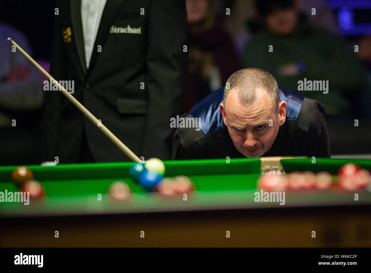 Mark Williams del Galles ritiene che un colpo di Mark Selby dell'Inghilterra in il loro match di primo turno durante il 2018 Dafabet Masters snooker nel torneo di Lond Foto Stock