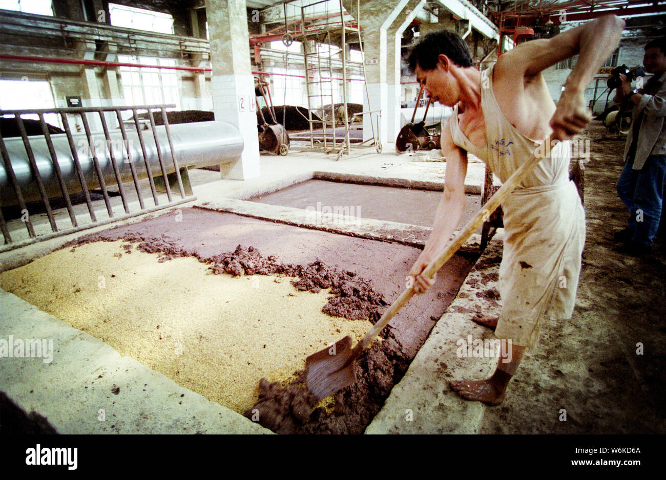Un lavoratore cinese fatiche in un serbatoio di fermentazione in un impianto di produzione di Kweichow Moutai in città Maotai, Renhuai city, a sud-ovest della Cina di Guizhou provin Foto Stock