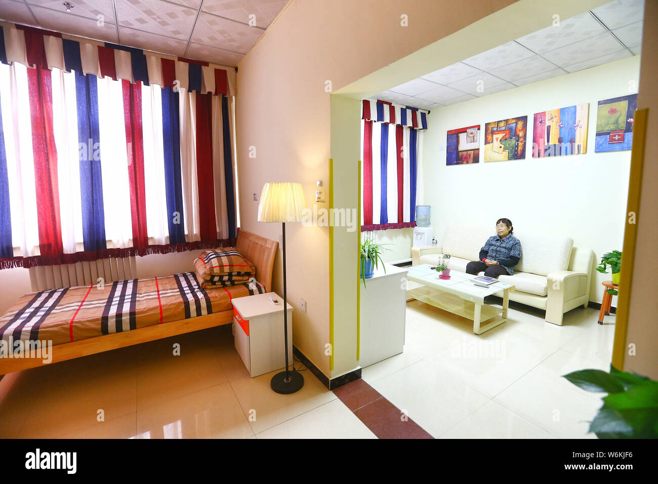 Una donna anziana orologi TV ad un AI nursing home costruito dai Cinesi e-commerce gigante gruppo Alibaba a Pechino, in Cina, il 26 dicembre 2017. Un nursi Foto Stock