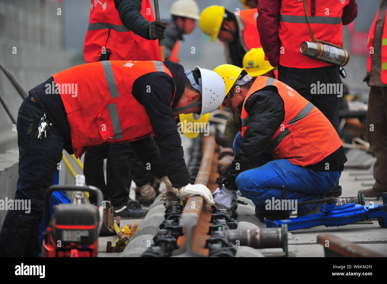 Lavoratori cinesi spianare i primi 500 metri sulla rampa del Chengdu West Grand Bridge presso il cantiere per la costruzione della sezione Chengdu-Pujiang per il Si Foto Stock