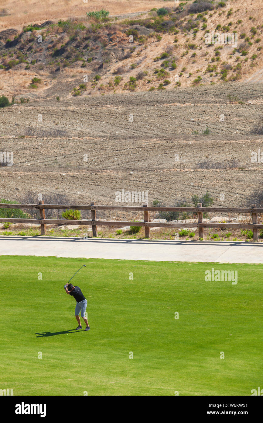 Il Golfer giocare vicino a semi-arido ambiente. Campi da golf il concetto di sostenibilità Foto Stock