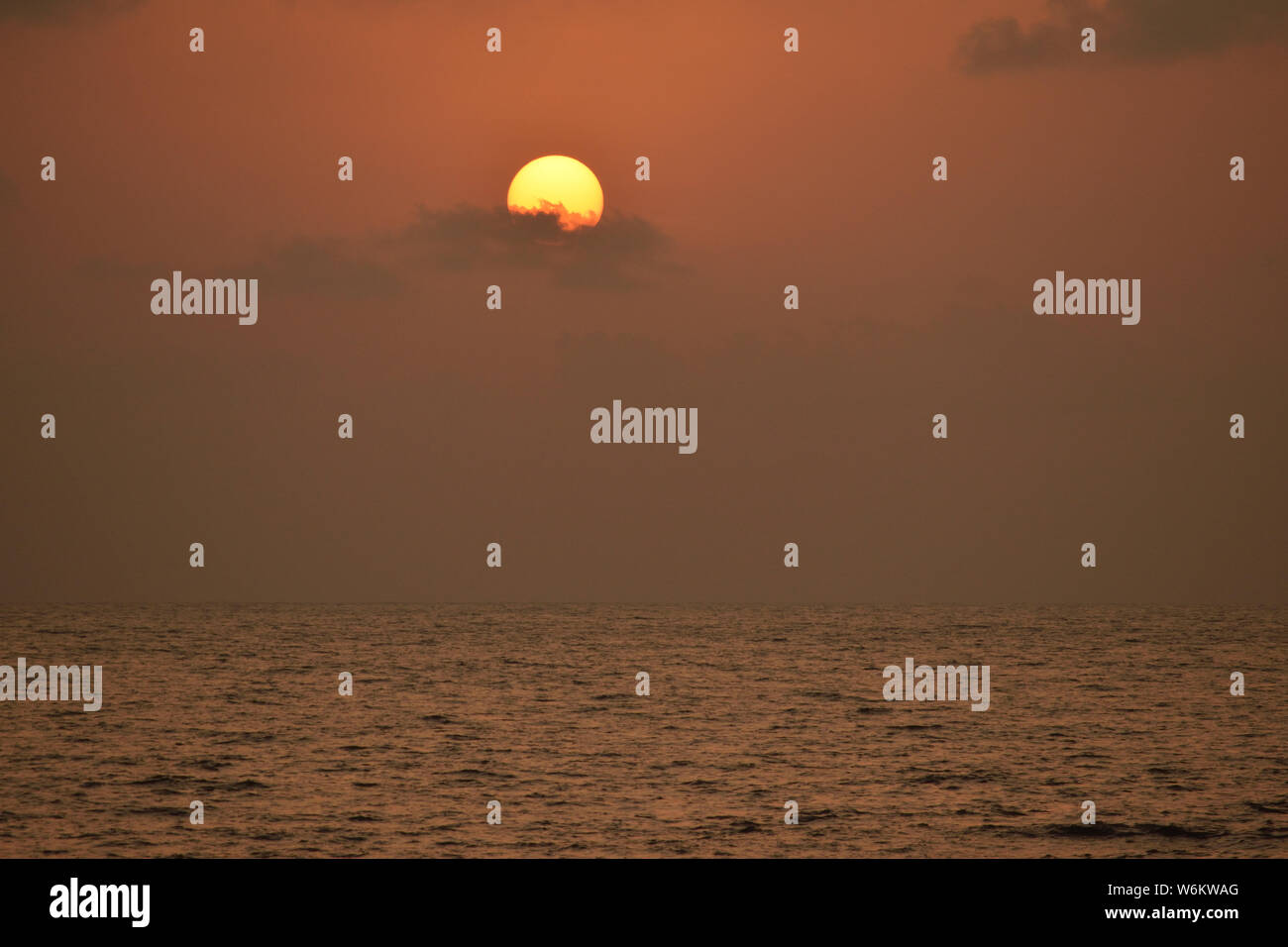 Bagliore dorato del sole al tramonto sul mare Foto Stock