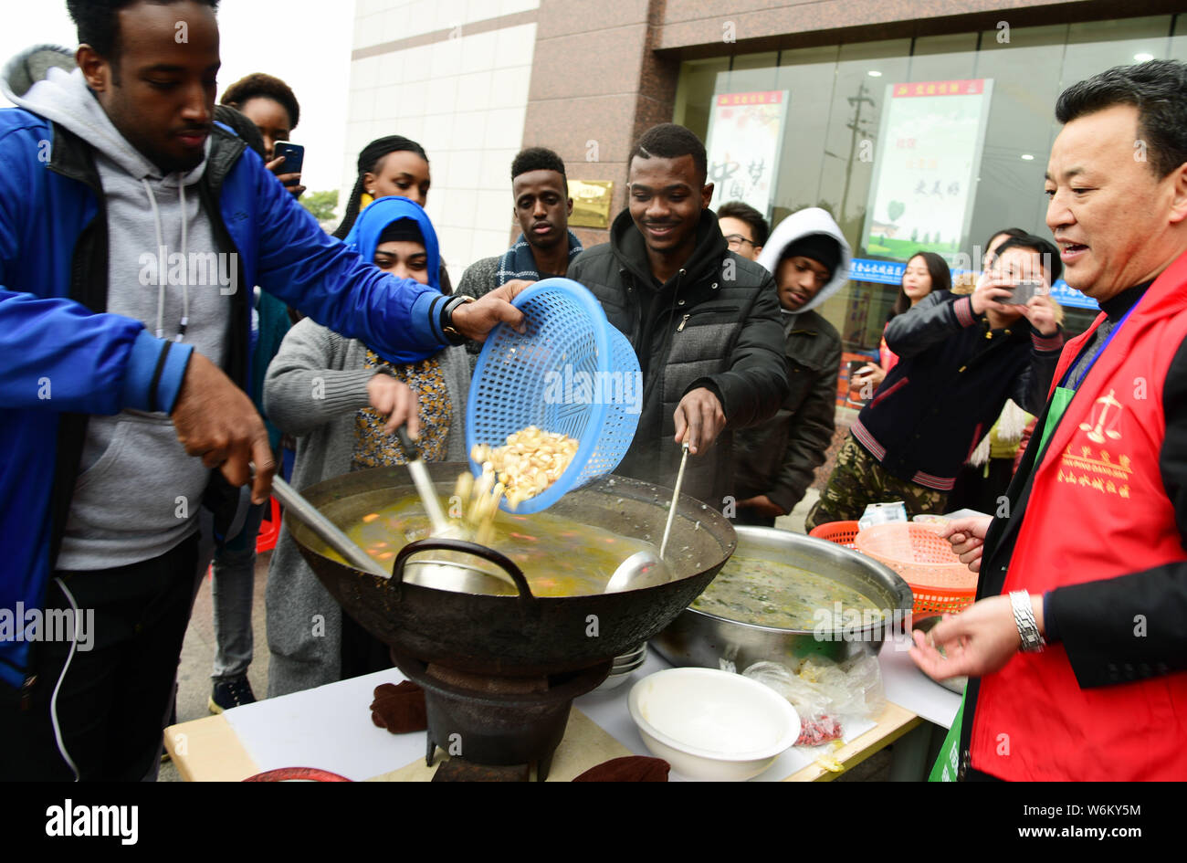 Gli studenti stranieri rendere Laba porridge in corrispondenza dello Jiangsu università nella città di Zhenjiang, est cinese della provincia di Jiangsu, 22 gennaio 2018. La Laba Festival, un tr Foto Stock