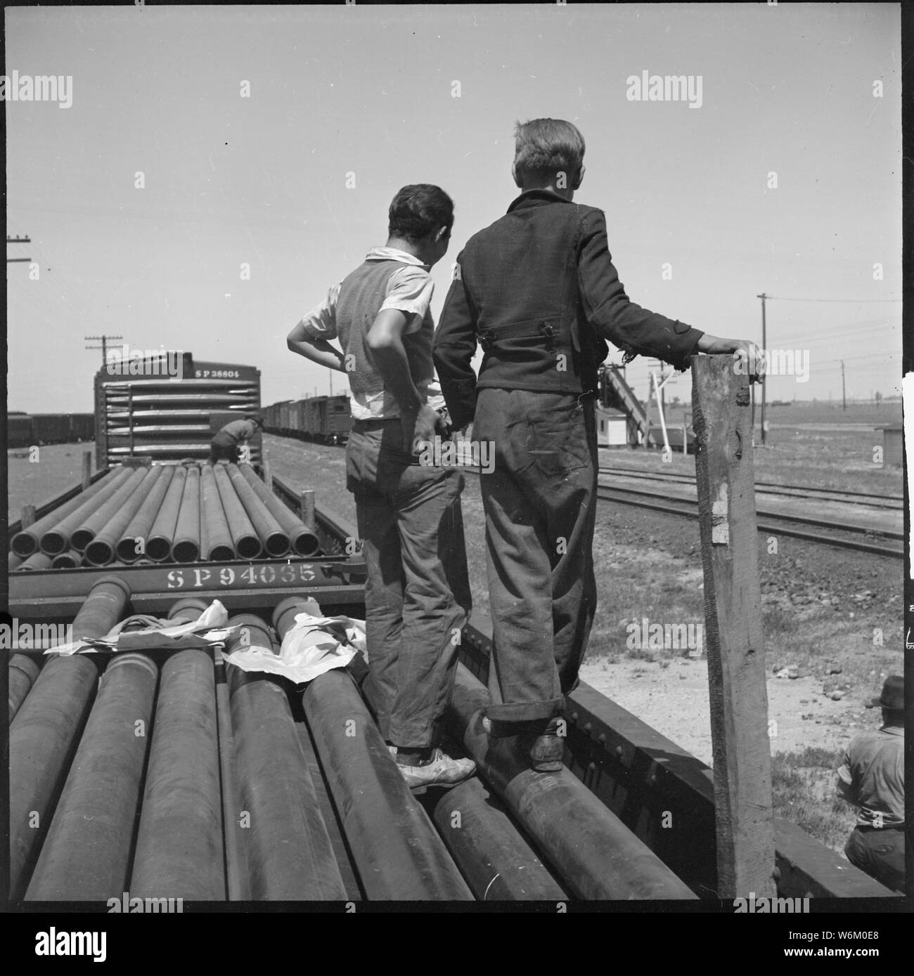 San Joaquin Valley, California. Sui Trasporti. Due ragazzi di età compresa tra i quindici e sedici in viaggio in compagnia di un vecchio hobo, campo di applicazione e il contenuto: San Joaquin Valley, California. Sui Trasporti. Due ragazzi di età compresa tra i quindici e sedici in viaggio in compagnia di un vecchio hobo. Qui essi sono di ritorno per il treno dopo aver riempito alcuni vuoti di bottiglie di whisky con acqua potabile presso la ferrovia alla torre d'acqua. Il più vecchio ha detto di aint et fin da ieri mattina. E quindi non pubblicare il mio bricco in documenti. Se il mio paw vide, hed beat inferno fuori di me. Im sposed per essere thumbing. La loro stor Foto Stock