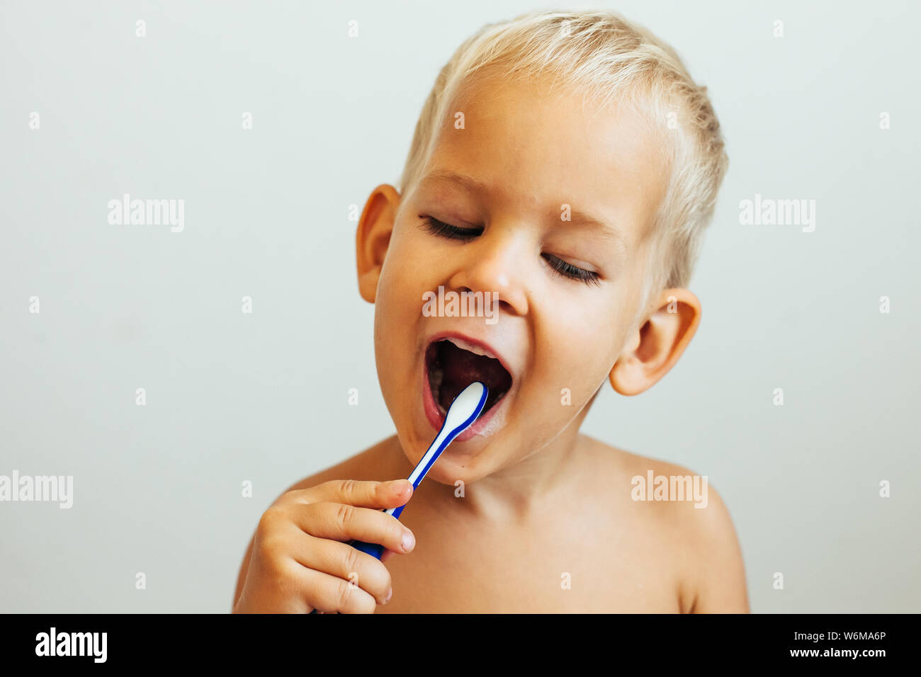 Sorridente ragazzino spazzolatura dei denti Foto Stock