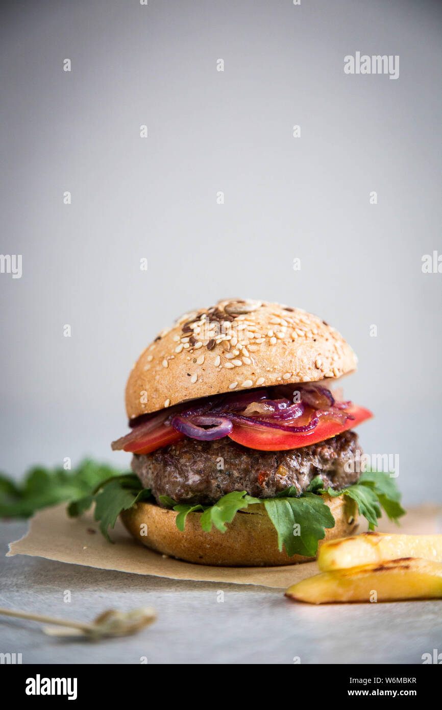 Artigianato in casa carni bovine hamburger e patatine fritte. Sfondo luminoso, spazio di copia Foto Stock