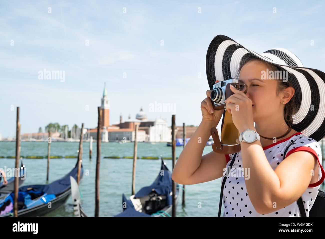 Turista femminile di scattare le foto con la fotocamera nella parte anteriore della chiesa di San Giorgio Maggiore a Venezia Foto Stock