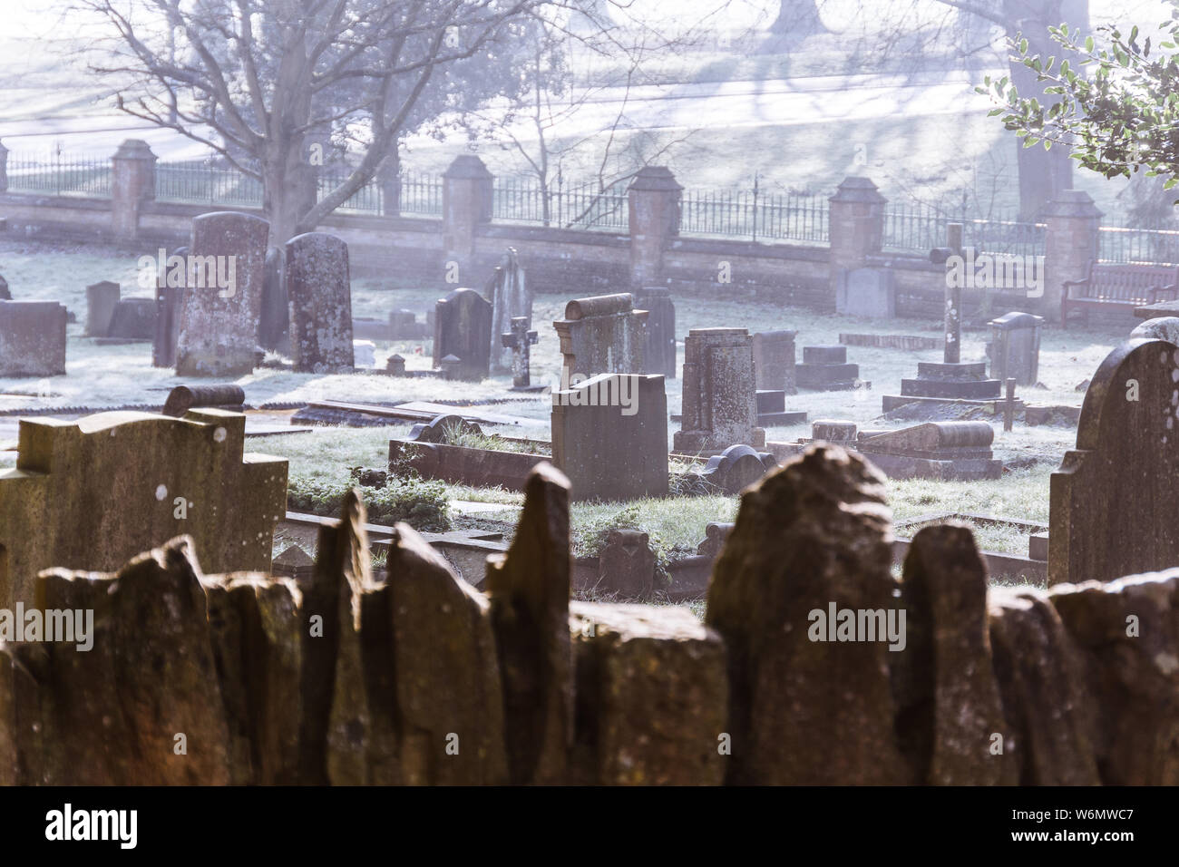 Il cimitero in una nebbiosa e frosty mattina a Abington Park Church, Northampton Regno Unito Foto Stock