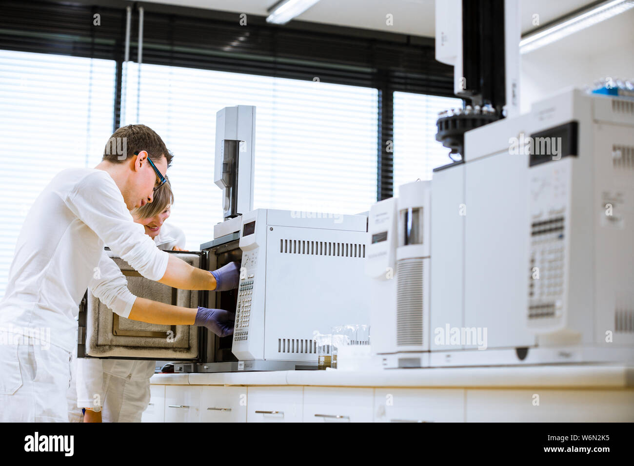 Maschio senior researcher di effettuare attività di ricerca scientifica in laboratorio utilizzando un gascromatografo (SHALLOW DOF; dai toni di colore immagine) Foto Stock