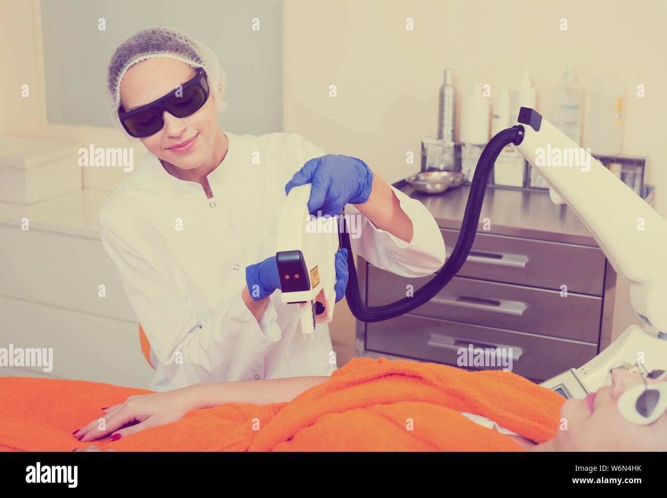 Giovani donne medico facendo Depilazione laser dai bracci Foto Stock