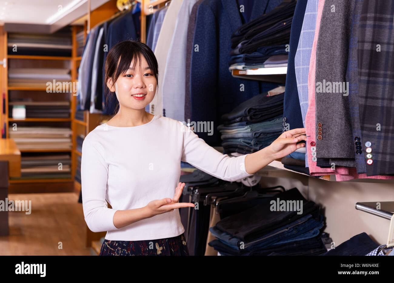Giovani cinesi commessa offerta vestito elegante cappotti in uomini negozio  di abbigliamento Foto stock - Alamy