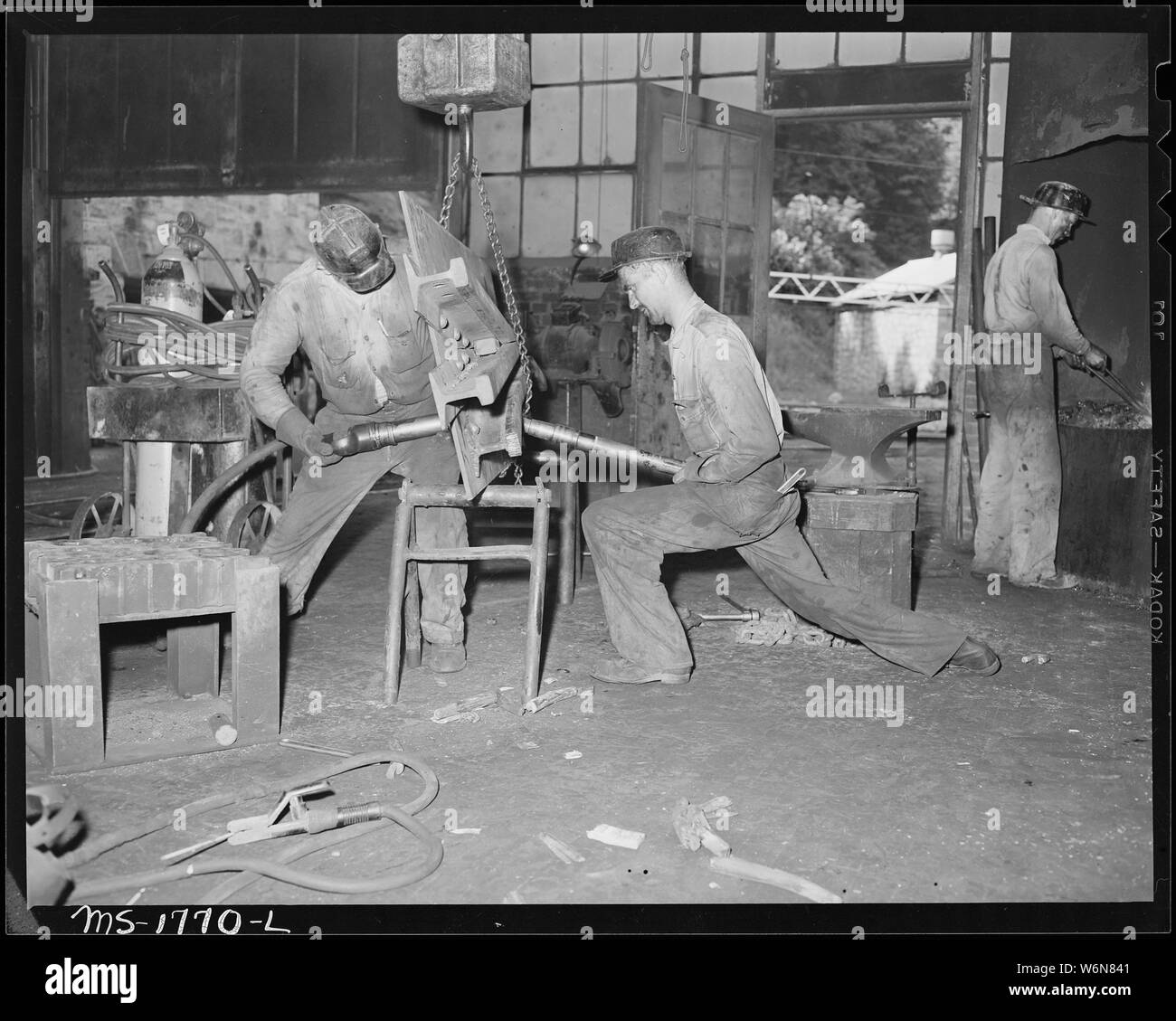 Woodrow agnello (sinistra) e Cyrus Williams rivetto una ferrovia frag su un basamento in una macchina negozio presso la miniera. Koppers divisione di carbone, Kopperston miniere, Kopperston, Wyoming County, West Virginia. Foto Stock