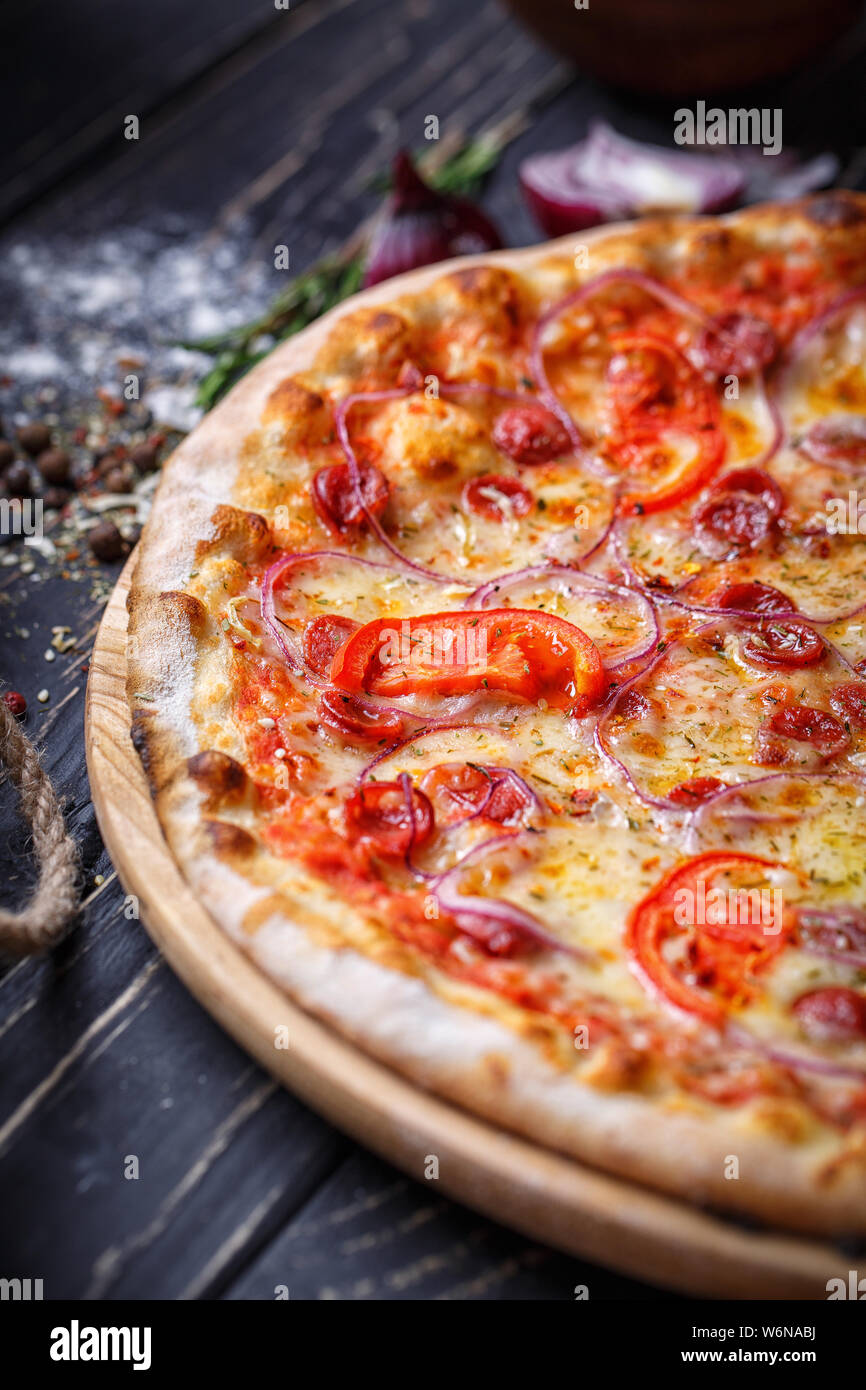 Pizza aromatica con salsicce da caccia, cipolle e pomodori Foto Stock